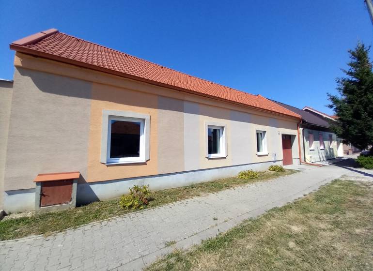 A family house in Trakovice with an orange facade and a red roof.