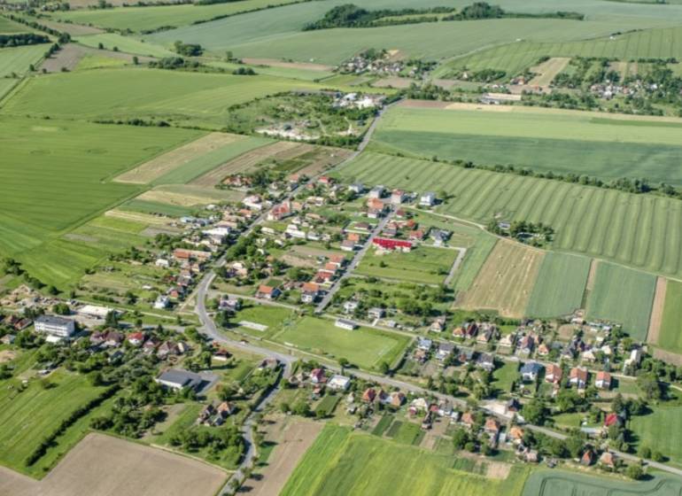 Aerial view of the village between fields in Kamenné Kosihy, ideal for commercial land.