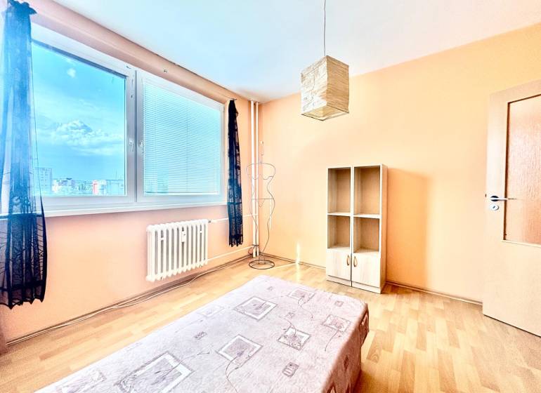 A bright room with a bed and a cabinet in a 3-room apartment.
