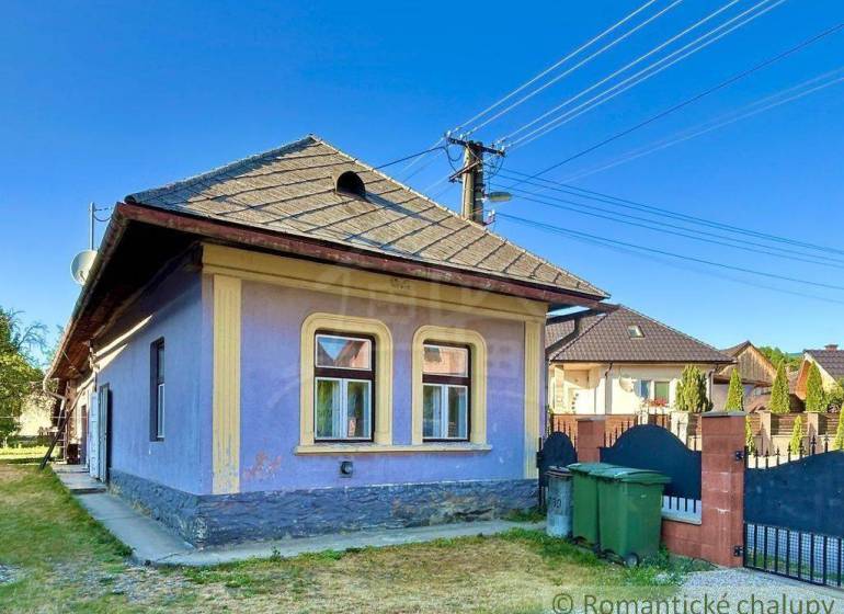 A family house in Gemerská Poloma with a blue facade and windows framed in yellow.
