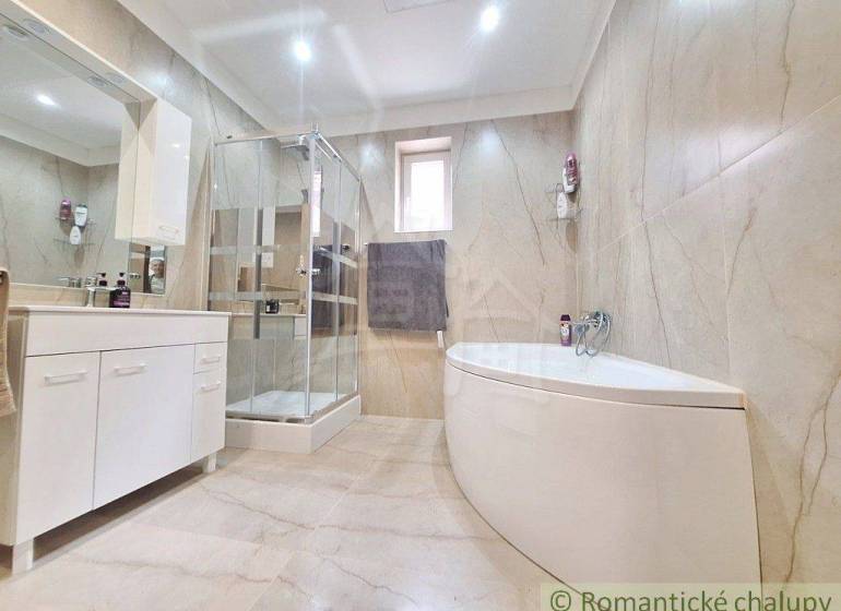 Bathroom with a bathtub and shower in a family house.