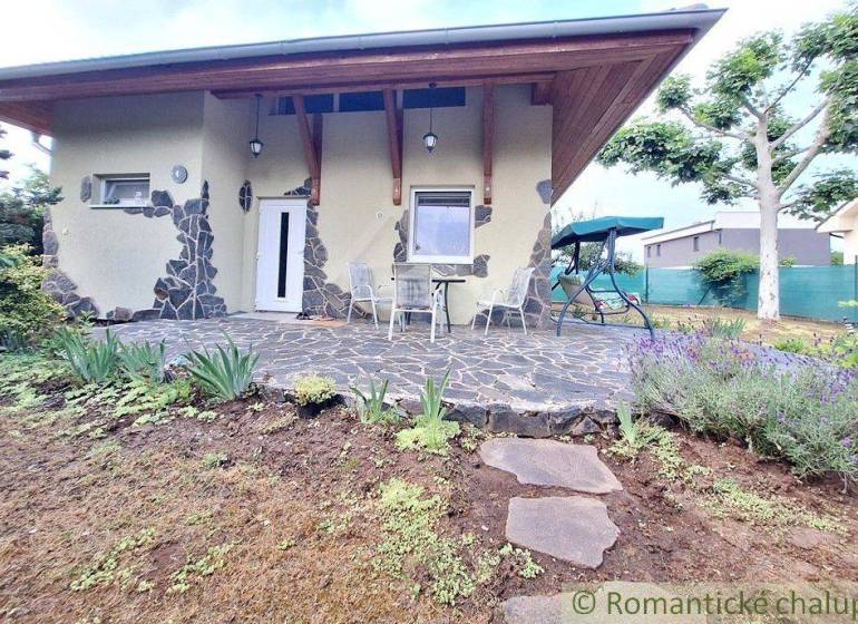A family house in Komárno with a covered terrace, seating, and a swing in the garden.