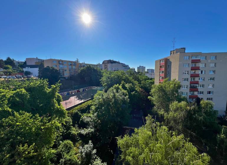 Sunny view of greenery and buildings from a 2-room apartment on Ladzianskeho in Bratislava.