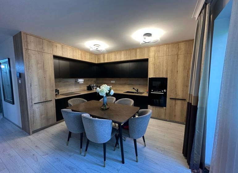 A kitchen in a family house with wooden furniture and a dining table.
