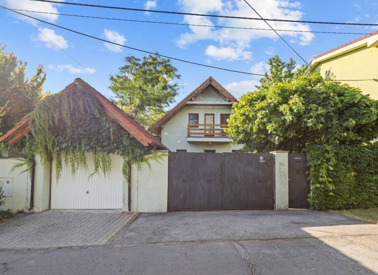 A family house on Senecká Street in Pezinok, with a gate and greenery in the surroundings.