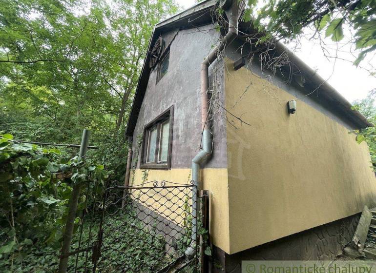 A family house in Branč surrounded by greenery with a gate and a gutter system.