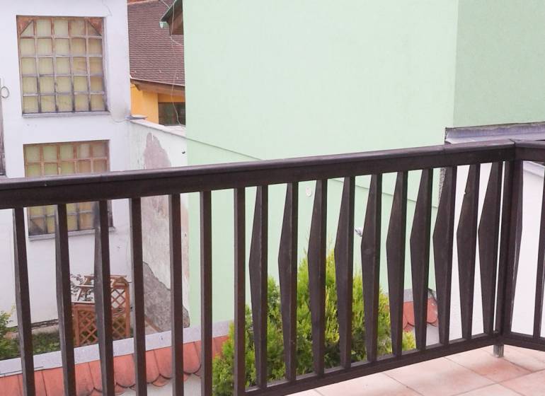 A balcony with a view of buildings, a 2-room apartment on Vrátna Street in Košice.