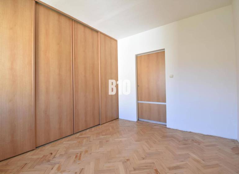 A room with a built-in wardrobe and wooden floor in a 4-room apartment.