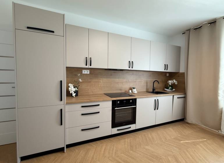 A kitchen in a 3-room apartment with a complete set of cabinets, a wooden countertop, and decorations.