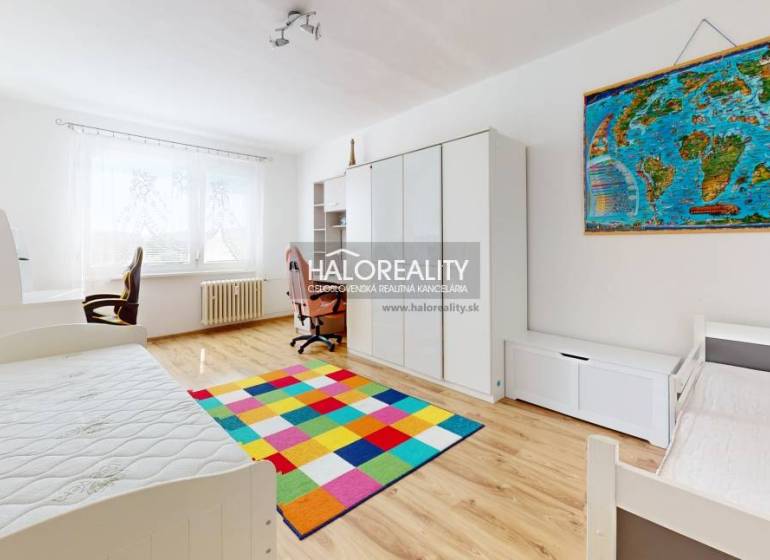 Children's room in a 3-room apartment with a colorful carpet and a desk.