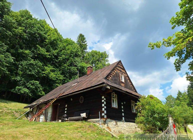 A cottage in Zákopčie surrounded by forests and beautiful nature under a cloudy sky.