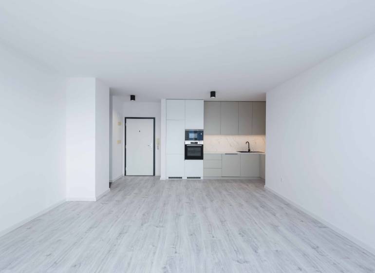 A bright kitchen with a floor in a 3-room apartment, equipped with built-in appliances.