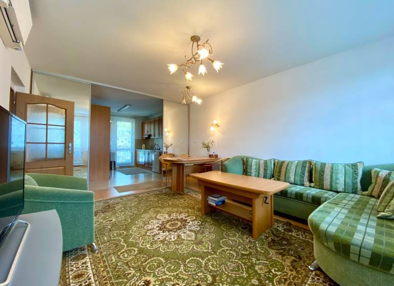 Living room with a comfortable sofa and a dining table in a 3-room apartment.