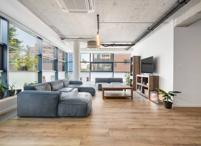 Interior of a 4-room apartment with a spacious living room, large windows, and comfortable seating.