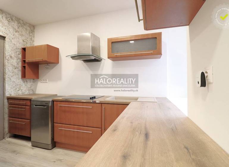 A kitchen with appliances, wooden cabinets, and a countertop, all in a family house.
