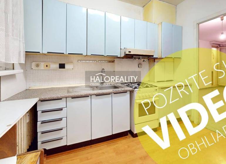 A kitchen in a 3-room apartment with blue cabinets, wooden flooring, and a gas stove.