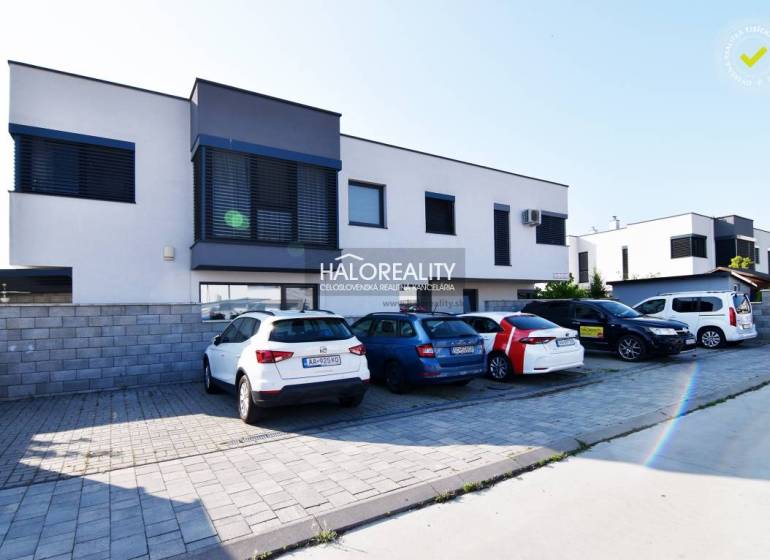 A family house in Rovinka with parking and a modern facade, surrounded by cars.
