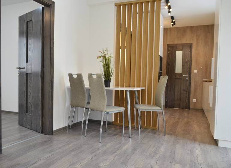 Dining area with three chairs and a table in a 3-room apartment.
