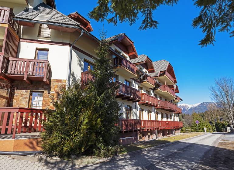 Exterior of a 2-bedroom apartment in Donovaly with balconies and a mountain backdrop.