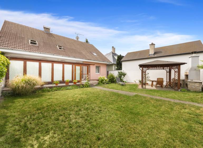 The garden of a family house in Vinosady with a wooden gazebo and a lawn.