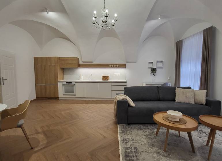 2-bedroom apartment with vaulted ceilings, a modern kitchen, and a comfortable living room with a chandelier.