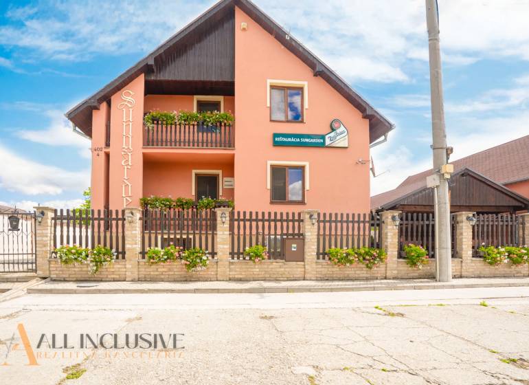 Guesthouse with a wooden fence and floral decorations in the town of Veľký Meder.