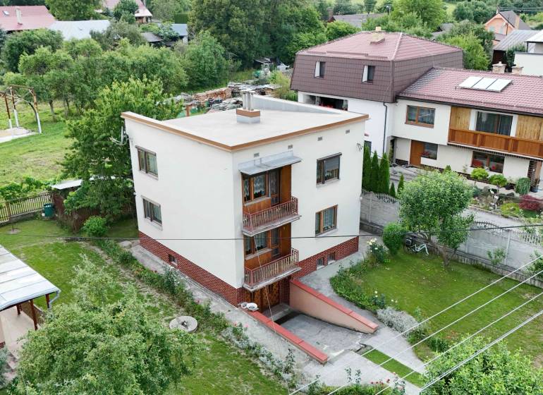 A family house in Dolná Mariková surrounded by greenery and neighboring houses in a peaceful environment.