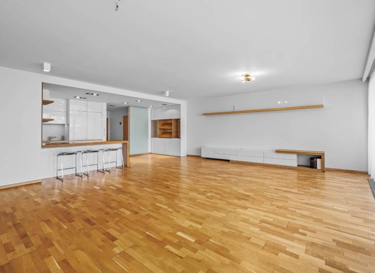 A spacious living room with a bar counter and wooden flooring, 3-room apartment.
