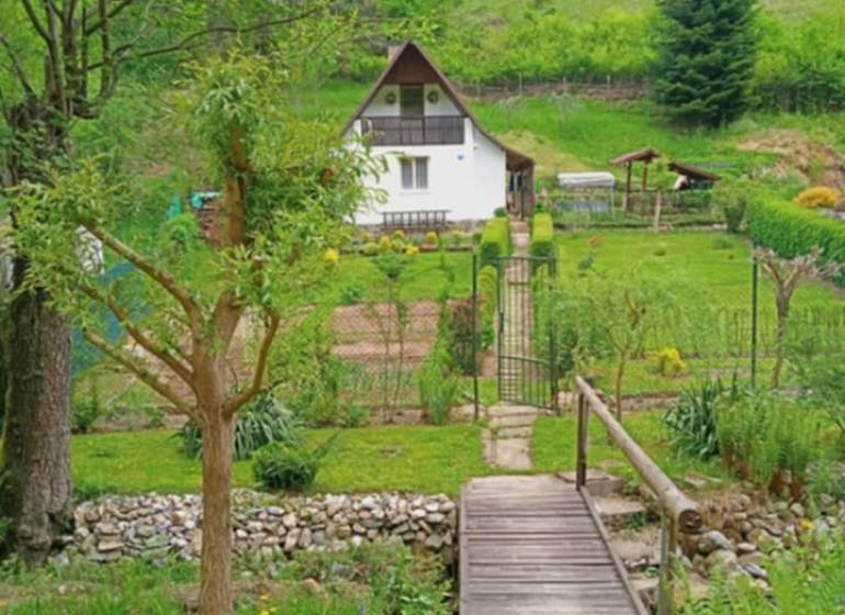 A cottage in Malá Lodina on Ružín Street with a landscaped garden in a natural setting.