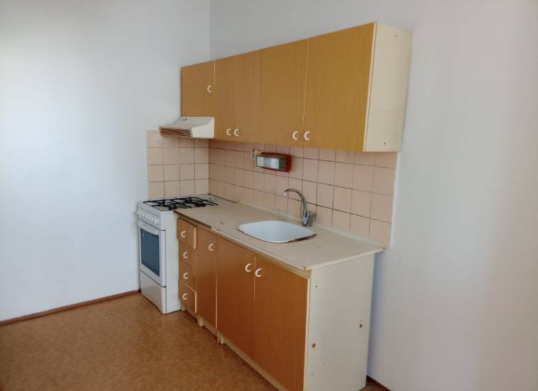 A kitchen unit with a stove and a range hood in a 3-room apartment.