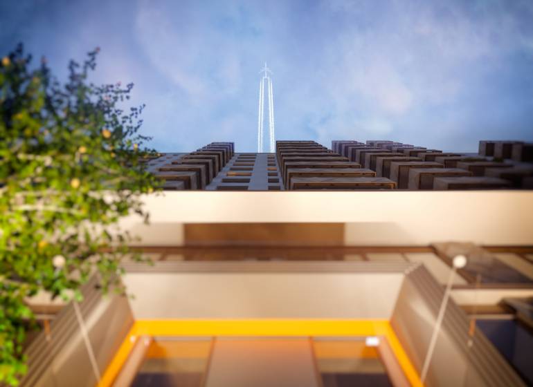 A view from below of a building with a flying airplane, Bratislava - Petržalka, Panónska cesta.