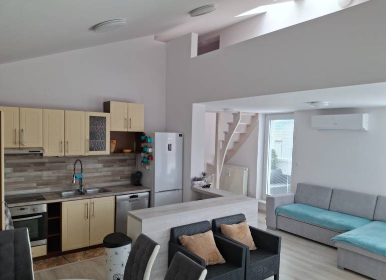 Living room with kitchen, sofa, and stairs in a 4-room apartment.