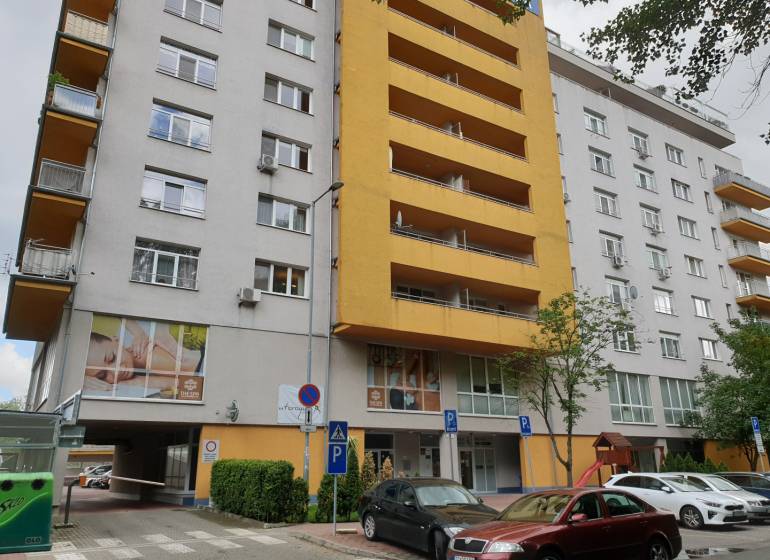 Apartment building in Bratislava on Antolská Street with parking and a children's playground.