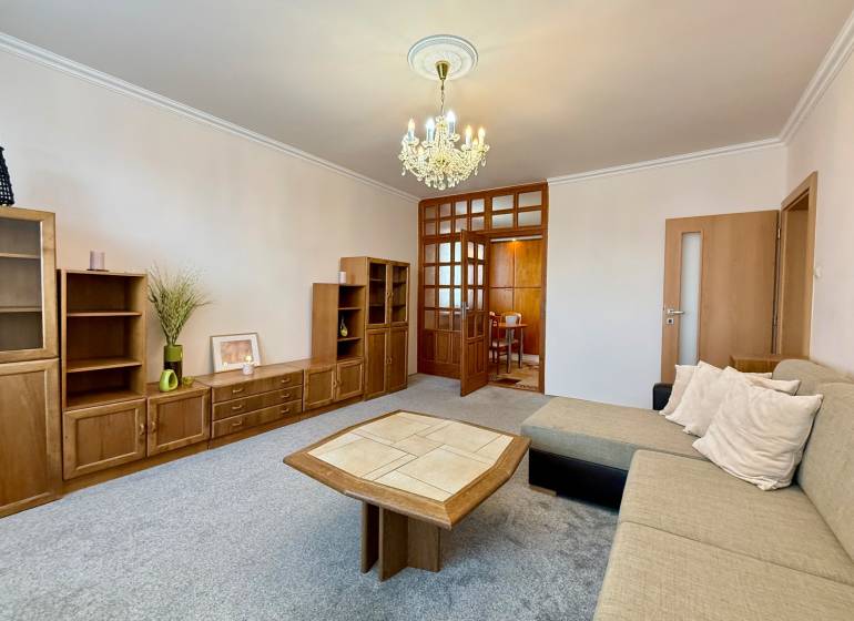 Living room in a 3-room apartment with wooden furniture and a sofa, pleasant atmosphere.