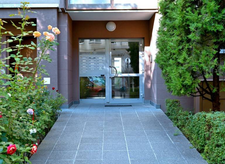 The entrance to the apartment building on Ondavská Street in Bratislava - Nivy surrounded by greenery.
