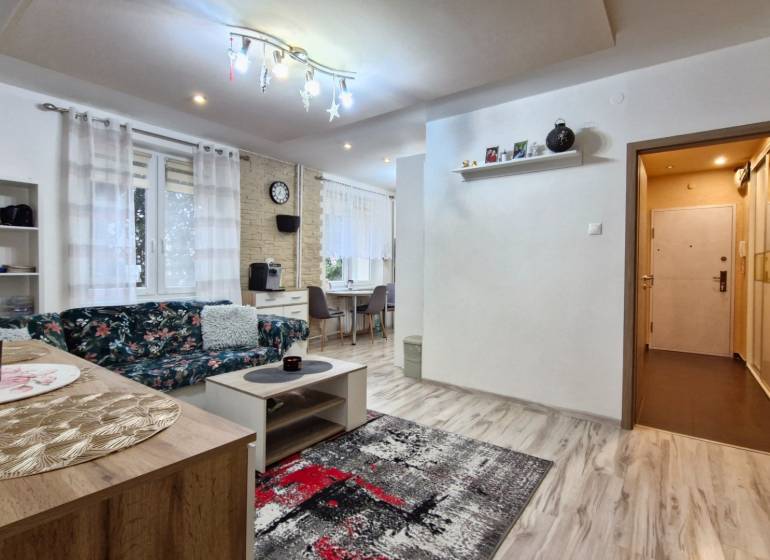 Living room in a 3-room apartment with a comfortable sofa, modern curtains, and a dining table.