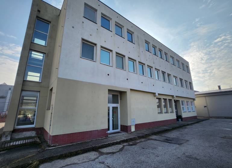 The building on Továrenská Street in Smolenice with a row of windows.