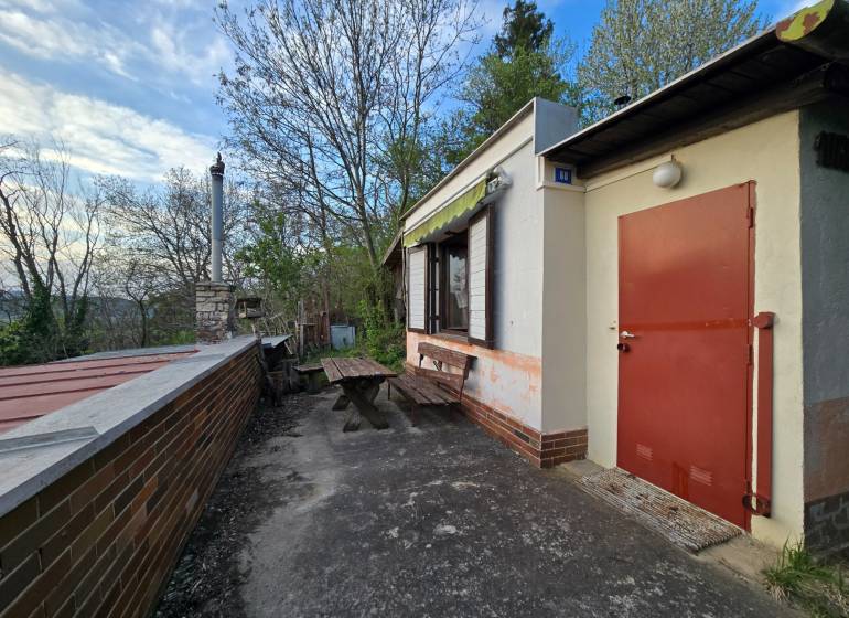 A cottage on Sychrov Street in Beckov with an outdoor seating area by the table and chimney.