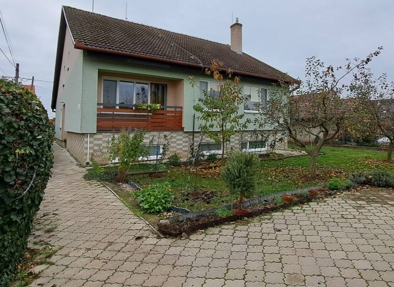 A family house in Levice with a landscaped garden and a paved access road.