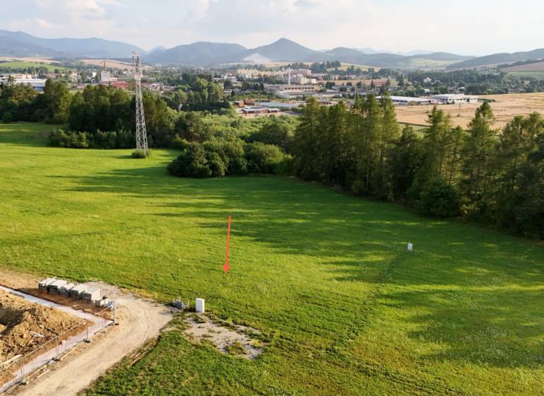 Panoramic view of residential building plots in Kľače with visible power pylons.