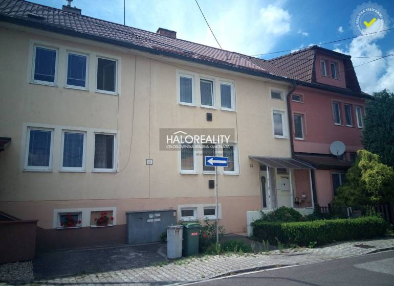 A family house in Nováky with a garage and floral decorations on the facade.