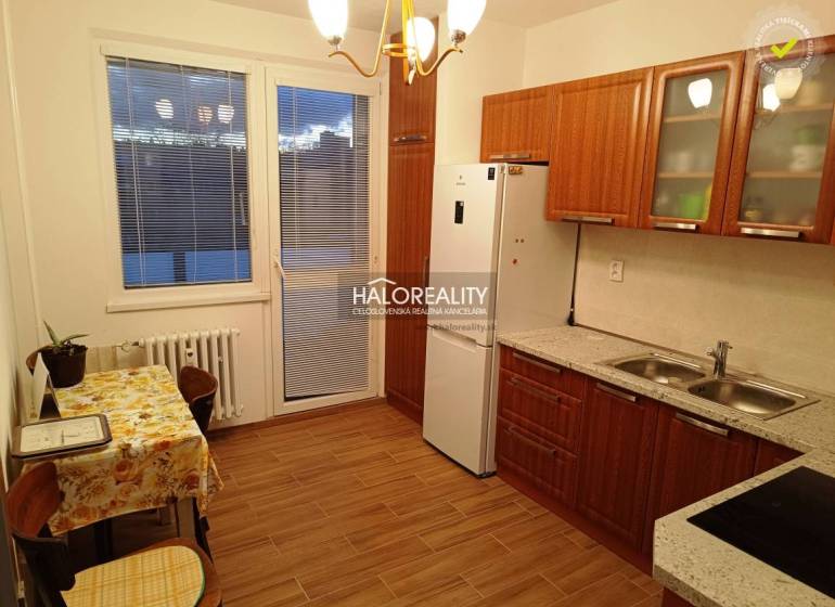 Kitchen and space in a 2-room apartment with a wooden kitchen unit and table.