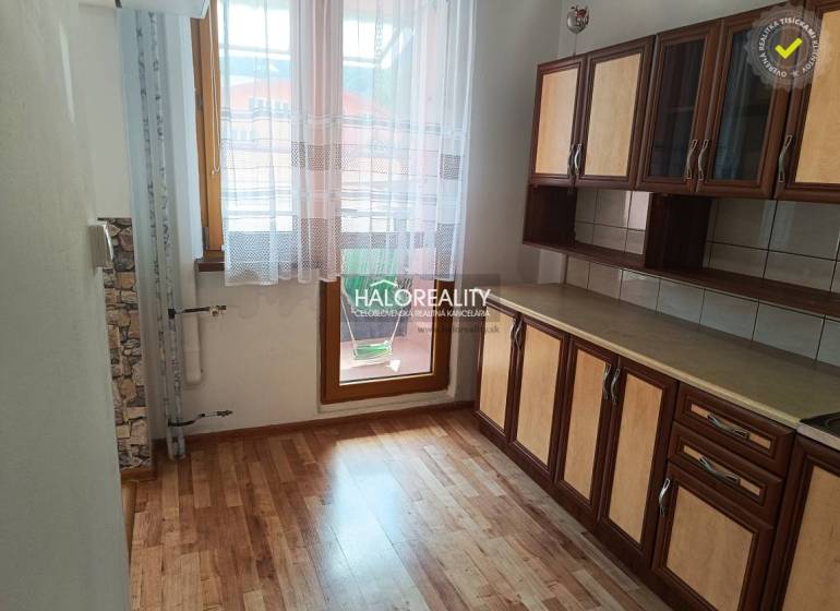 A kitchen in a 3-room apartment with a wooden floor and a kitchen unit.