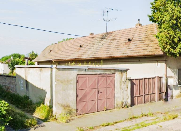 A family house in Reca with a garage and an older roof.