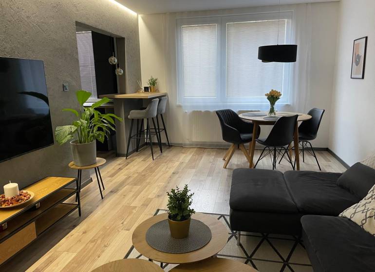 Living room in a 3-room apartment with a sofa, dining table, and television.