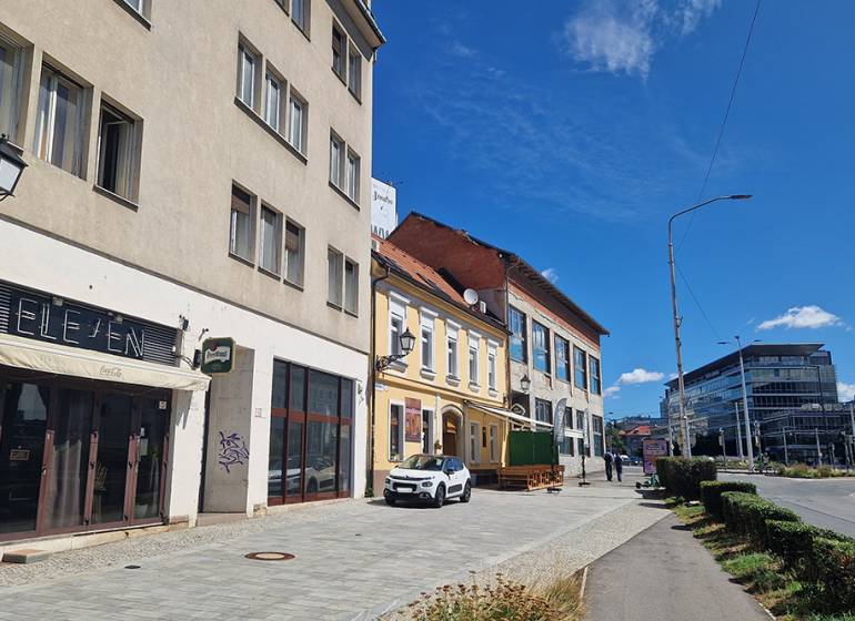 Commercial premises on Konventná Street in Bratislava - Old Town with cars and pedestrians.