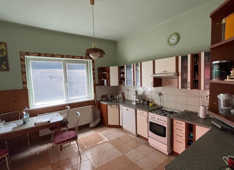 A kitchen in a family house with a dining table and kitchen unit.