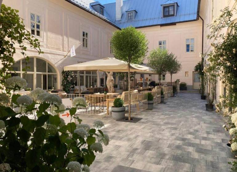 In the historic courtyard of a 2-room apartment in Banská Štiavnica, we find a cozy terrace with flowers.
