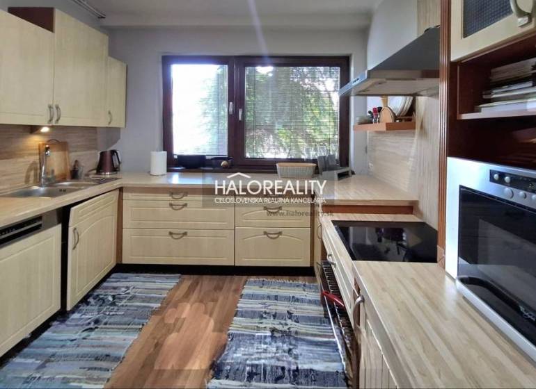 A kitchen in a family house with wooden cabinets and a kitchen counter.