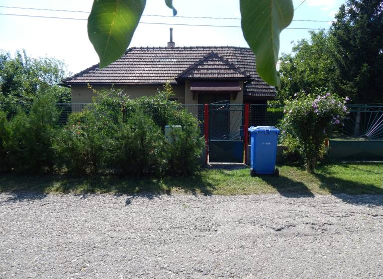 The exterior of the cottage in Klížska Nemá, surrounded by greenery and a gate.